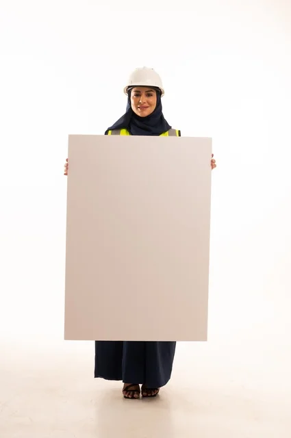 Marketing offers and advertisements, women's professions and jobs in the engineering sector, the role of structural engineering in the development of Saudi society, a portrait of a Muslim Arab Gulf engineer wearing a white helmet and safety vest holding a white board, full-body, white background.