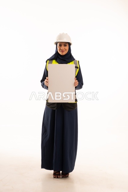 White rectangular mock-up, marketing presentations and advertisements, the role of structural engineering in the development of Saudi society, a portrait of a Muslim Arab Gulf Saudi female engineer wearing a white helmet and safety vest holding a white board, full-body, white background.