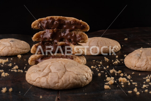 صورة لقطع من البسكويت المقرمش متناثر على الطاولة , قطع البسكويت المحشوة بقطع الشوكولاتة  . 