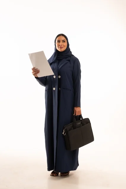 النظر بإيماءات التأمل والتمني، متابعة المهام اليومية المكتبية وقراءة الملاحظات, بورتريه لإمرأة عربية خليجية سعودية مبتسمه ترتدي العباءة تحمل حقيبة الأعمال وورقة بيضاء, أناقة النساء الخليجيات, الاهتمام بالمظهر الخارجي, الجسم بالطول الكامل، خلفية بيضاء