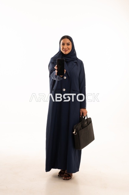A black screen background on a mobile phone working through modern technologies, a portrait of a smiling Saudi Gulf Arab woman wearing an abaya holding a business bag, the elegance of Gulf women, attention to external appearance, full-length body, white background.