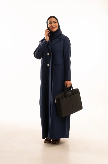 Making a work phone call through modern technologies, a portrait of a smiling Saudi Gulf Arab woman wearing an abaya and carrying a business bag, the elegance of Gulf women, attention to appearance, full-length body, white background.
