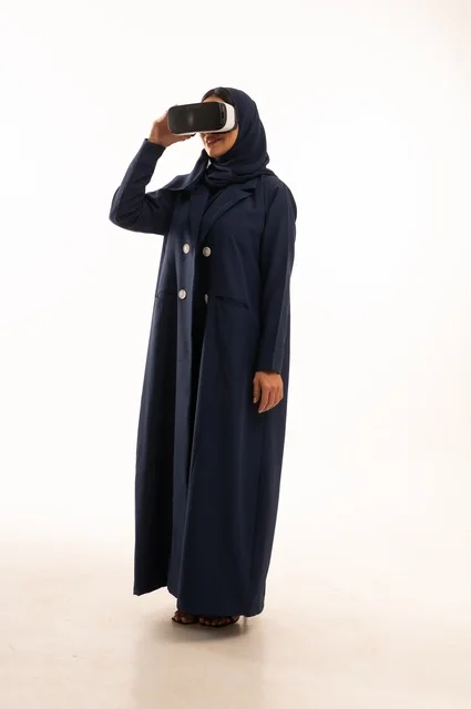 قضاء أوقات ممتعة ودمج التكنولوجيا في الحياة اليومية، بورتريه لإإمرأة عربية خليجية سعودية سعيدة ترتدي نظارة الواقع الإفتراضي ثلاثية الأبعاد الفريدة و العجيبة، التفاعل و المتعة و التسلية بمشاهدة الأفلام و ألعاب العالم الافتراضي ، تقنيات و ألعاب ، خلفية بيضاء