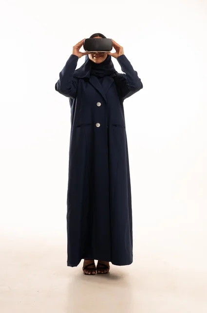 قضاء أوقات ممتعة ودمج التكنولوجيا في الحياة اليومية، بورتريه لإإمرأة عربية خليجية سعودية سعيدة ترتدي نظارة الواقع الإفتراضي ثلاثية الأبعاد الفريدة و العجيبة، التفاعل و المتعة و التسلية بمشاهدة الأفلام و ألعاب العالم الافتراضي ، تقنيات و ألعاب ، خلفية بيضاء