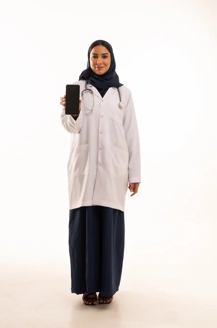 سسسعرض خلفية شاشة سوداء على الهاتف المحمول، استخدام التقنية الحديثه المتطورة في الحياة العملية، بورتريه لإمرأة عربية خليجية سعودية ترتدي الحجاب والعباءة تقوم بالعمل على الهاتف المحمول، متابعة وتصفح مواقع التواصل الاجتماعي، صورة الجسم بالطول الكامل، خلفية بيضاء