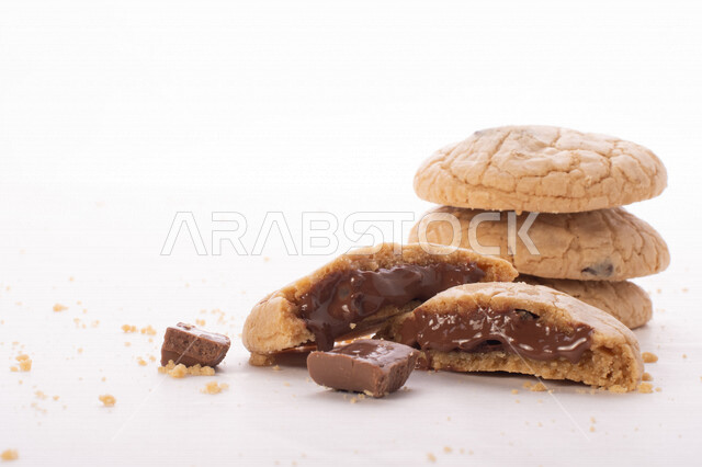 صورة لقطع من البسكويت المقرمش متناثر على الطاولة , قطع البسكويت المحشوة بقطع الشوكولاتة  . 