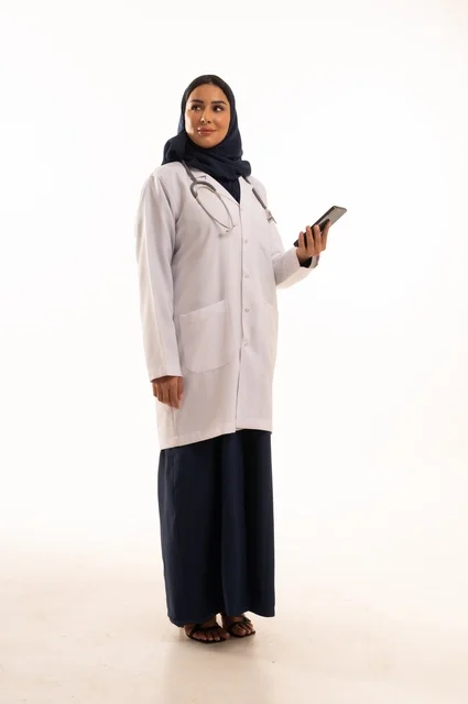 تعابير وايماءات الاندماج والسرور، استخدام التقنية الحديثه المتطورة في الحياة العملية، بورتريه لإمرأة عربية خليجية سعودية ترتدي الحجاب والعباءة تقوم بالعمل على الهاتف المحمول، متابعة وتصفح مواقع التواصل الاجتماعي، صورة الجسم بالطول الكامل، خلفية بيضاء