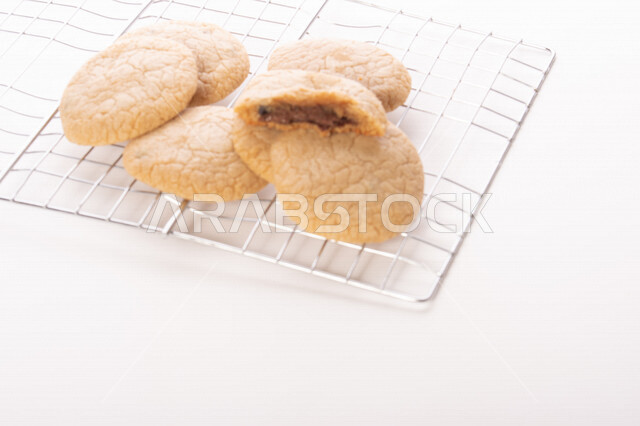 صورة لقطع من البسكويت المقرمش متناثر على الطاولة , قطع البسكويت المحشوة بقطع الشوكولاتة  . 