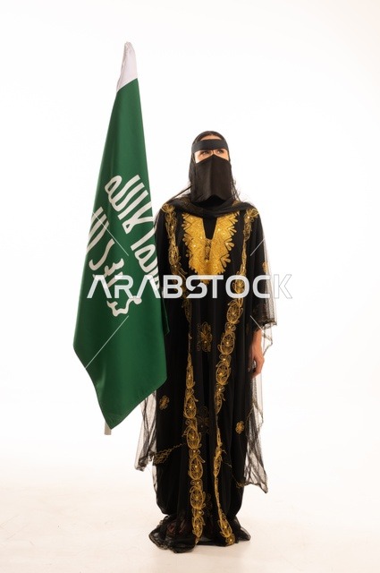 The anniversary of the day we began in 1727 AD, the establishment of the first Saudi state on February 22, wearing the traditional attire of the central region during popular and national occasions, a portrait of a Saudi Gulf Arab woman wearing a burqa and shayla holding the flag and emblem of the Foundation Day with expressions of pride and honor, full-body, white background.
