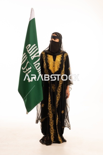 تأسيس الدولة السعودية الأولى 22 فبراير، ذكرى يوم بدينا 1727 م، ارتداء زي المنطقة الوسطى في المناسبات الشعبية والوطنية, بورتريه لإمرأة عربية خليجية سعودية ترتدي البرقع والشيلة تمسك راية وشعار يوم التأسيس بتعابير الفخر والاعتزاز, الجسم بالطول الكامل, خلفية بيضاء