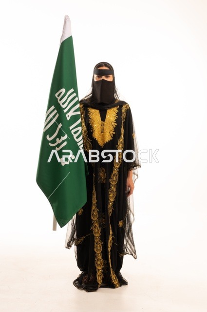 تأسيس الدولة السعودية الأولى 22 فبراير، ذكرى يوم بدينا 1727 م، ارتداء زي المنطقة الوسطى في المناسبات الشعبية والوطنية, بورتريه لإمرأة عربية خليجية سعودية ترتدي البرقع والشيلة تمسك راية وشعار يوم التأسيس بتعابير الفخر والاعتزاز, الجسم بالطول الكامل, خلفية بيضاء