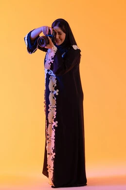 سيدة سعودية تمارس الهوايات المفضله ،إلتقاط الصور التذكارية ،كاميرا عالية الدقة ،مفهوم إحتراف التصوير  ، بورتريه لامراه عربيه خليجيه اماراتيه تحمل بيدها كاميرا تصوير عالية الدقة ، مصوره اماراتيه ، خلفية صفراء