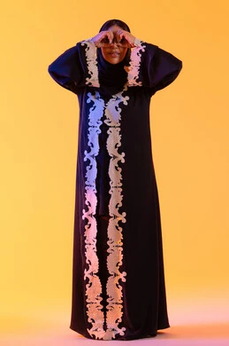 Seeing distant things and bringing them closer, a Saudi woman who loves exploration and adventure, a portrait of an Arab Gulf Emirati woman wearing an abaya and hijab, raising her hand with gestures of binoculars and looking with expressions of joy and enjoyment.