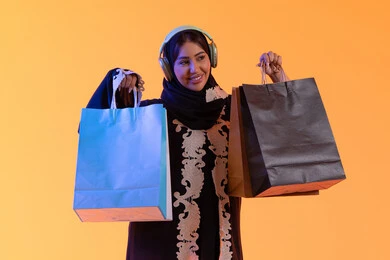 الأثر الإيجابي للتسوق على السيدات، سيدة سعودية تستفيد من العروض الموسمية والتخفيضات، سماع الموسيقي عبر الهيدفون ، التبضع والتسوق من الماركات العالميه، بورترية لسيده عربية خليجية اماراتيه مبتسمة ترتدي العباءه والحجاب تحمل بيدها أكياس التسوق الملونه، ، خلفية صفراء الأثر الإيجابي للتسوق على السيدات، سيدة سعودية تستفيد من العروض الموسمية والتخفيضات، سماع الموسيقي عبر الهيدفون ، التبضع والتسوق من الماركات العالميه، بورترية لسيده عربية خليجية اماراتيه مبتسمة ترتدي العباءه والحجاب تحمل بيدها أكياس التسوق الملونه، ، خلفية صفراء