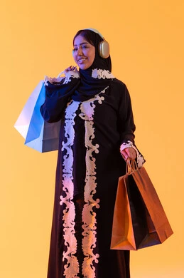 الأثر الإيجابي للتسوق على السيدات، سيدة سعودية تستفيد من العروض الموسمية والتخفيضات، سماع الموسيقي عبر الهيدفون ، التبضع والتسوق من الماركات العالميه، بورترية لسيده عربية خليجية اماراتيه مبتسمة ترتدي العباءه والحجاب تحمل بيدها أكياس التسوق الملونه، ، خلفية صفراء الأثر الإيجابي للتسوق على السيدات، سيدة سعودية تستفيد من العروض الموسمية والتخفيضات، سماع الموسيقي عبر الهيدفون ، التبضع والتسوق من الماركات العالميه، بورترية لسيده عربية خليجية اماراتيه مبتسمة ترتدي العباءه والحجاب تحمل بيدها أكياس التسوق الملونه، ، خلفية صفراء