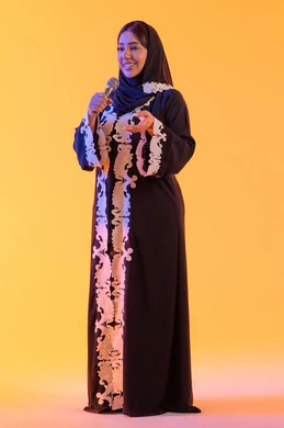 تعابير الاندماج والتفاعل مع الموسيقي، تقديم العروض الصوتية ، تسجيل مقطع صوتي غنائي، تقديم البرامج الاذاعية، ممارسة موهبة الغناء، بورتريه لامراه عربيه خليجيه اماراتيه ترتدي العباءه المطرزة والحجاب تمسك بيدها المايكروفون ، سيده سعوديه تغني بإيماءات الحماس والسرور، خلفية صفراء