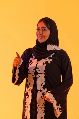 البشاشة والشعور بالسعادة ،سيده سعوديه تشير بتعابير الرضي والموافقة ،  التعبير عن الجودة والاتقان، بورتريه لامراه عربيه خليجيه اماراتيه ترتدي العباءه والحجاب تقوم برفع ايديها بإيماءات الجودة والامتياز والتميز