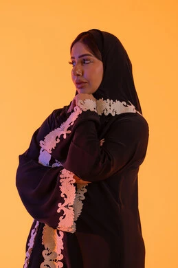 Trying to find a solution to difficult problems, anxiety and confusion in making the right decision, deep thinking and distraction, a portrait of an Arab Gulf Emirati woman wearing an abaya and hijab with her hand under her chin, a Saudi woman standing with gestures of integration.