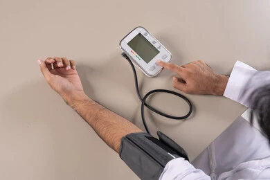 العناية والاهتمام والحفاظ على الصحة, المتابعة الدورية لفحص الدم, بورتريه مقرب لرجل عربي خليجي اماراتي يرتدي الكندورة الاماراتية يقوم بقياس ضغط الدم باستخدام الميزان الالكتروني, مفهوم الطب والرعاية الصحية, خلفية بيضاء