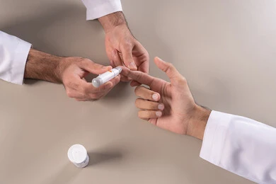 الالام الجسدية والحالات المرضية, مشاكل ارتفاع السكر في الدم, بورتريه مقرب علوي لأيدي رجل عربي خليجي اماراتي يقوم بفحص نسبة السكر في الدم, الرعاية الصحية والفحص الطبي السريع, الأجهزة الالكترونية الحديثة لمرضى داء السكري, خلفية بيضاء