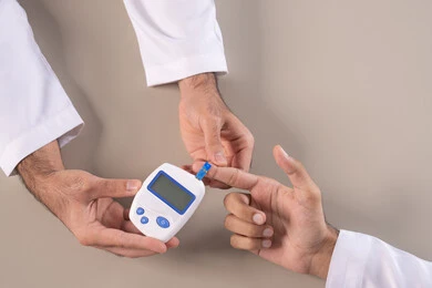 الأجهزة الالكترونية الحديثة لمرضى داء السكري, مشاكل ارتفاع السكر في الدم, الالام الجسدية والحالات المرضية, بورتريه مقرب علوي لأيدي رجل عربي خليجي اماراتي يقوم بفحص نسبة السكر في الدم, الرعاية الصحية والفحص الطبي السريع, خلفية بيضاء