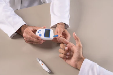 الالام الجسدية والحالات المرضية, مشاكل ارتفاع السكر في الدم, بورتريه مقرب علوي لأيدي رجل عربي خليجي اماراتي يقوم بفحص نسبة السكر في الدم, الرعاية الصحية والفحص الطبي السريع, الأجهزة الالكترونية الحديثة لمرضى داء السكري, خلفية بيضاء