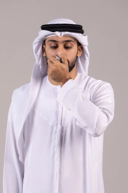 أجهزة استنشاق المخصصة للمرضى، المحافظة على ممر هوائي منتظم، مشاكل في الجهاز التنفسي، بورتريه لرجل عربي خليجي اماراتي يرتدي الكندورة والغترة الاماراتية يحمل بيده جهاز الرذاذ الخاص بمرض الربو، خلفية بيضاء