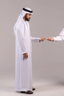 مشاكل ارتفاع السكر في الدم، الإصابة بداء السكري، بورتريه لشاب عربي خليجي اماراتي مريض يرتدي الكندورة والغترة الاماراتية يقوم بفحص نسبة السكر في دمه، أجهزة الكترونية حديثة للفحص الطبي السريع، الجسم بالطول الكامل, خلفية بيضاء