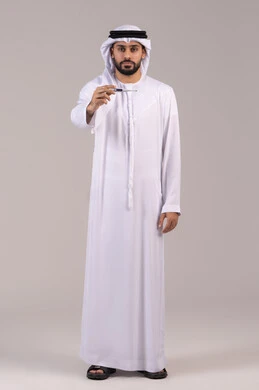 الشعور بالإرهاق والتعب وأعراض الحمى ، الحاجة إلى المساعدة الطبية, أهمية وجود ميزان رقمي في المنزل، بورتريه لرجل عربي خليجي اماراتي يرتدي الكندورة والغترة يمسك بيده جهاز مقياس الحرارة يقوم بقياس درجة حرارته, الجسم بالطول الكامل، خلفية بيضاء