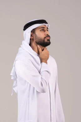 الشعور بآلام في الحلق، التألم وعدم القدرة على التنفس والاحساس بالاختناق، أمراض البلعوم والتهاب اللوزتين، بورتريه لرجل عربي خليجي اماراتي يرتدي الكندورة والغتره يضع يديه حول عنقه بإيماءات المعاناة والتوجع، خلفية بيضاء