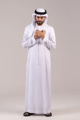 الاحساس بذبحه صدريه، بورتريه لشاب عربي خليجي إماراتي يرتدي الزي التقليدي يضع يده على صدره، الشعور بحالة سيئة من الوخز والألم, اضطرابات وأمراض قلبية, التعب والإرهاق والضغوطات النفسية, ضرورة الذهاب للطبيب لتلقي العلاج المناسب، الطول الكامل للجسم، خلفية بيضاء