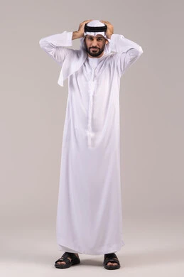 الاحساس بالشقيقية والصداع النصفي, الاجهاد والضغط النفسي, بورتريه لرجل عربي خليجي اماراتي يرتدي الكندورة والغترة يضع يديه على رأسه ويغمض عينيه بإيماءات الألم الشديد, الإرهاق وفقدان التركيز, الشعور بالصداع وألم الرأس, الطول الكامل للجسم، خلفية بيضاء