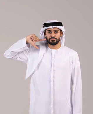 الاشارة بإصبع السبابة إلى الوجه، الشعور بآلام الفك والأسنان، الوقوف باستقامة والنظر إلى الكاميرا بإيماءات الثقة بالنفس، مفهوم الاهتمام بالمظهر الخارجي، بورتريه لرجل عربي خليجي اماراتي يرتدي الكندورة والغترة ، خلفية بيضاء