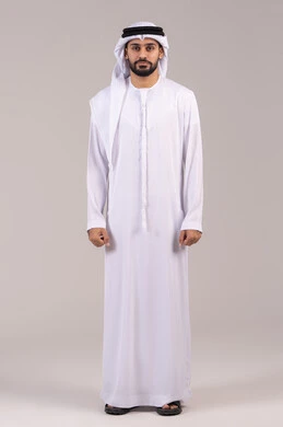 مفهوم الاناقة والوسامة والاهتمام بالمظهر الخارجي، الوقوف باستقامة والنظر إلى الكاميرا بإيماءات الثقة بالنفس، بورتريه لرجل عربي خليجي اماراتي يرتدي الكندورة والغترة ، الطول الكامل للجسم، خلفية بيضاء