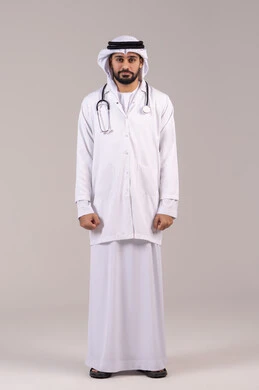 الوقوف باستقامة بإيماءات الثقة بالنفس، العمل في القطاع الصحي في الامارات، الفحص الطبي وتقديم الخدمات العلاجية للمرضى, بورتريه لطبيب عربي خليجي اماراتي يرتدي الكندورة والغترة والمعطف الطبي يضع السماعة الطبية ينظر إلى الكاميرا، الجسم بالطول الكامل، خلفية بيضاء