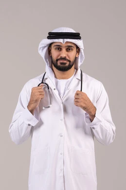 الفحص الطبي وتقديم الخدمات العلاجية للمرضى, الوقوف باستقامة بإيماءات الثقة بالنفس، العمل في القطاع الصحي في الامارات، بورتريه لطبيب عربي خليجي اماراتي يرتدي الكندورة والغترة والمعطف الطبي يضع السماعة الطبية ينظر إلى الكاميرا، خلفية بيضاء