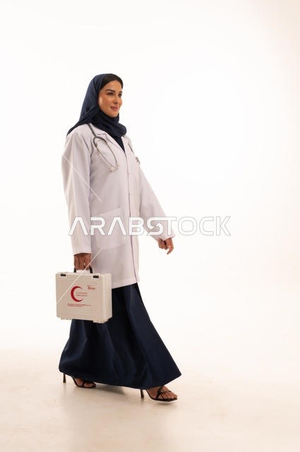 اطبيبة تقوم بالأسعاف الأولي، بورتريه لطبيبة عربية خليجية سعودية ترتدي العباءة والمئزر الأبيض تمسك بيديها حقيبة الأسعافات الاولية، شابة سعودية تنظر إلى الكاميرا بتعابير الحزم والجدية, لوحات توضيحية ووسائل تعليمية, خلفية بيضاء