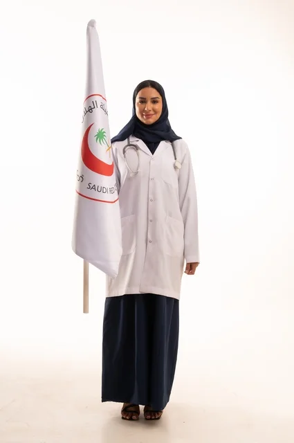 The Saudi crescent flag, the concept of medicine and healthcare, a portrait of an Arab Gulf Saudi female doctor wearing an abaya and a white coat holding a flag with the Red Crescent logo, a young Saudi woman looking at the camera with expressions of determination and seriousness, white background.