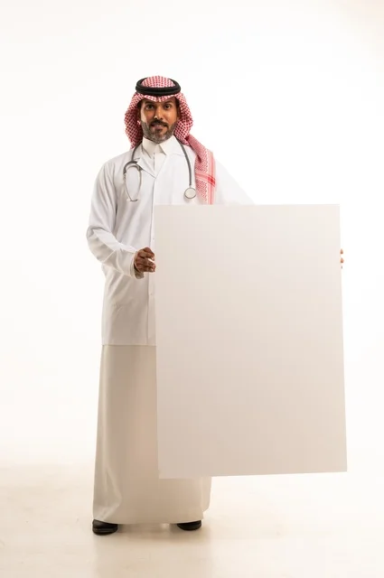 لوحات توضيحية ووسائل تعليمية, العروض والإعلانات التسويقية, بورتريه لطبيب عربي خليجي سعودي يرتدي الثوب التقليدي والمئزر الأبيض يمسك بيديه لوحة بيضاء مستطيلة فارغة، شاب سعودي ينظر إلى الكاميرا بتعابير الحزم والجدية، موك اب مستطيل أبيض, خلفية بيضاء