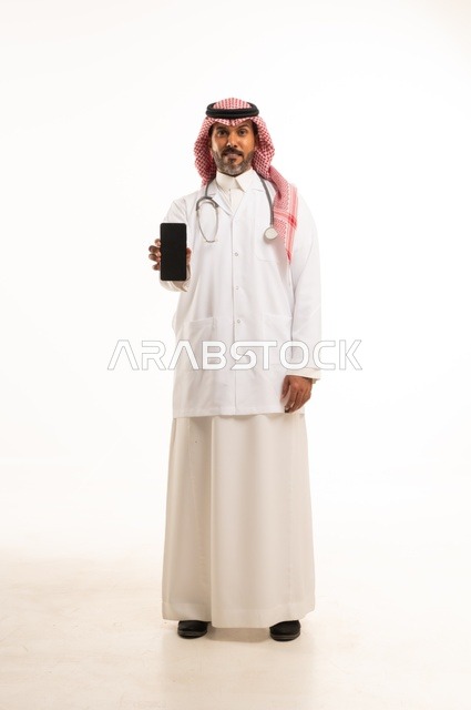 Display a black screen background on the mobile phone, attention to external appearance, providing medical examination and treatment services, a close-up portrait of a smiling Arab Gulf Saudi doctor wearing a doctor's coat and stethoscope, the concept of healthcare, white background.