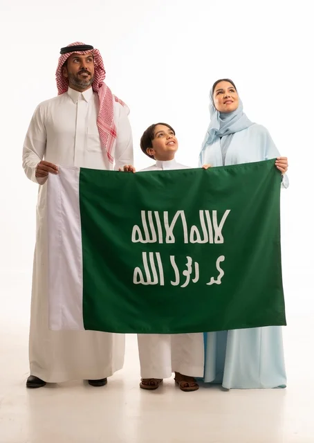 الأجواء العائلية المليئة بالحب، بورتريه لعائلة عربية خليجية سعودية سعيدة تمسك بعلم تأسيس المملكة السعودية 22 فبراير، الاحتفال بيوم العلم 11 مارس، العيد الوطني السعودي 8 ربيع الأول، ذكرى اليوم الوطني السعودي، الأعياد والمناسبات الوطنية السعودية، خلفية بيضاء