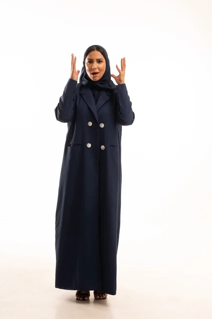 تعابير يد الصراخ والغضب، الاهتمام بالمظهر الخارجي والأناقة، تعابيرعبوس وتقضيب حاجبين، بورتريه لإمرأة عربية خليجية سعودية محجبة ترتدي عباءة، شابة سعودية ،مفهوم التعبير بالإشارة، صورة الجسم بالطول الكامل، خلفية بيضاء