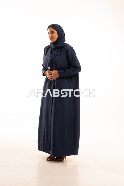 تعابير يد على البطن وجود خطبا ما، الاهتمام بالمظهر الخارجي والأناقة، تعابيرالألم والمعاناة، بورتريه لإمرأة عربية خليجية سعودية محجبة ترتدي عباءة، شابة سعودية ،مفهوم التعبير بالإشارة، صورة الجسم بالطول الكامل، خلفية بيضاء