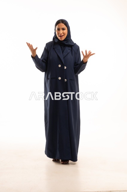 تعابير يد الصراخ والغضب، الاهتمام بالمظهر الخارجي والأناقة، تعابيرعبوس وتقضيب حاجبين، بورتريه لإمرأة عربية خليجية سعودية محجبة ترتدي عباءة، شابة سعودية ،مفهوم التعبير بالإشارة، صورة الجسم بالطول الكامل، خلفية بيضاء