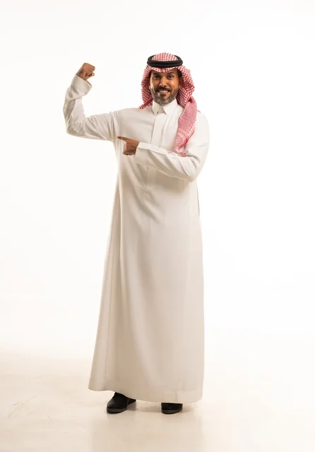 زيادة قدرة العضلات على التحمل، إتقان فنون الملاكمة، بورتريه لرجل عربي خليجي سعودي يرتدي الزي التقليدي يرفع قبضات يديه بإيماءات القوة، النظر إلى الكاميرا بتعابير الثقة بالنفس، ممارسة رياضة الدفاع عن النفس، الجسم بالطول الكامل، خلفية بيضاء