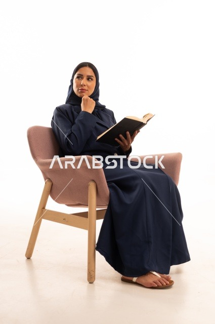 تعابير التفكير والتخيل، المطالعة والقراءة اكتساب معلومات ثقافية جديدة،الاهتمام بالمظهر الخارجي والأناقة، بورتريه لإمرأة عربية خليجية سعودية محجبة ترتدي عباءة تجلس على كرسي وردي تمسك بيدها كتاب، شابة سعودية ، خلفية بيضاء