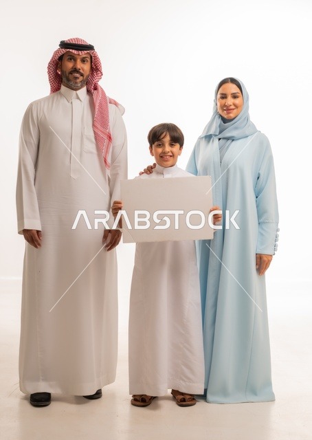الاعلانات والعروض التسويقية، استخدام لوحات توضيحية ووسائل تعليمية، بورتريه لعائلة عربية خليجية سعودية مبتسمة يقفون بإيماءات السعادة والسرور،  موك اب فارغ، ولد يحمل لوح أبيض كبير، خلفية بيضاء