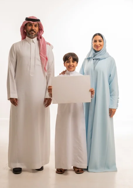 الاعلانات والعروض التسويقية، استخدام لوحات توضيحية ووسائل تعليمية، بورتريه لعائلة عربية خليجية سعودية مبتسمة يقفون بإيماءات السعادة والسرور،  موك اب فارغ، ولد يحمل لوح أبيض كبير، خلفية بيضاء