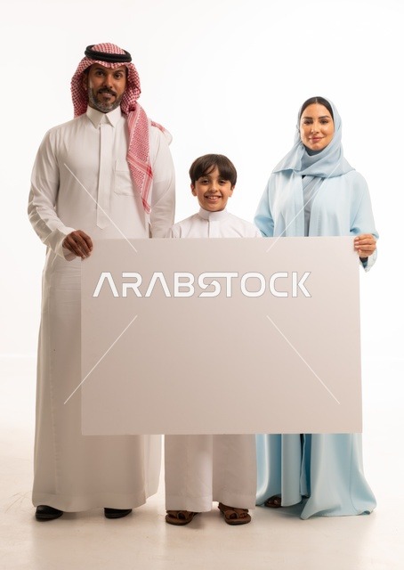 الاعلانات والعروض التسويقية، استخدام لوحات توضيحية ووسائل تعليمية، بورتريه لعائلة عربية خليجية سعودية مبتسمة يقفون بإيماءات السعادة والسرور،  موك اب فارغ، ولد يحمل لوح أبيض كبير، خلفية بيضاء