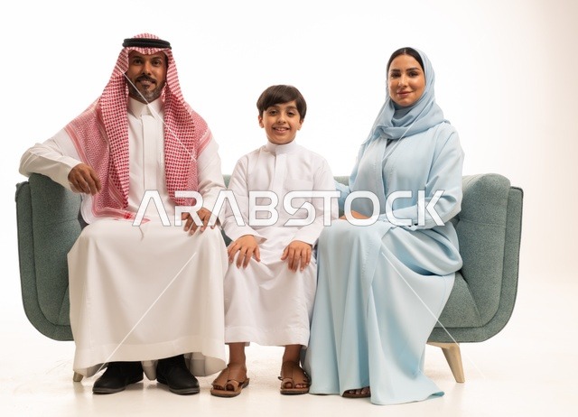 قضاء أوقات عائليه سعيده وممتعه في أيام العطله، نقاشات وحوارات الأباء مع الأبناء، بورتريه لأسره عربيه خليجيه سعودية تجلس على الاريكة وتتبادل أطراف الأحاديث، مفهوم العائله السعوديه المترابطه، بناء علاقات أسريه قويه، خلفية بيضاء.